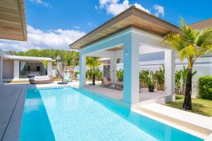 a swimming pool in the backyard of a villa at Mouana Breeze Mai Khao VIP 4-bedroom Pool Villa 9911 in Phuket