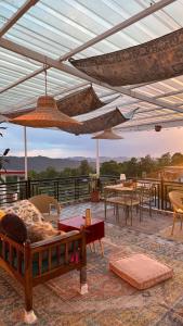 a patio with tables and chairs and umbrellas at Bir Haus in Bīr
