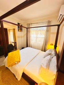 a bedroom with a large bed in front of a window at Easyhomes bungalow apartment in Dar es Salaam