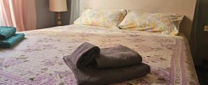 a bed with a pile of towels on it at Appartamento SoloSoleMare in Portovenere