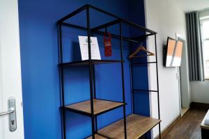 a black book shelf against a blue wall at Gutshof Vogt in Geismar +2 photos