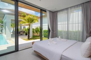 a bedroom with a bed and a large window at Mouana Breeze Mai Khao VIP 4-bedroom Pool Villa 9911 in Phuket +76 photos