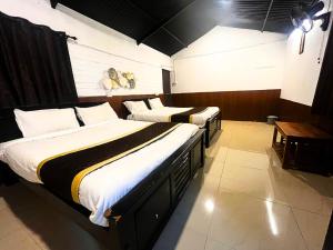 two beds in a hotel room at Resort Rover - Sampala in Masinagudi