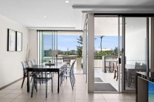 a dining room with a table and chairs on a balcony at Paradiso Resort by Kingscliff Accommodation in Kingscliff