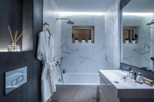 a bathroom with a white tub and a sink at Chanion One Suites by Good Life in Heraklio +25 photos
