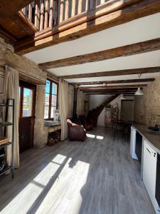 a large living room with wooden ceilings and wooden floors at L'Epicerie in Melay