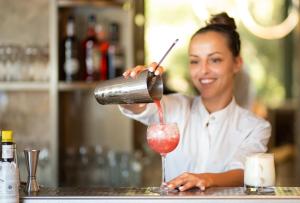 a woman is preparing a drink in a cocktail glass at Mitsis Bali Paradise in Bali +93 photos