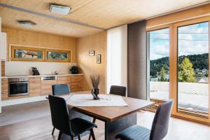 a kitchen and dining room with a wooden table and chairs at FeWo Nocky in Turracher Hohe