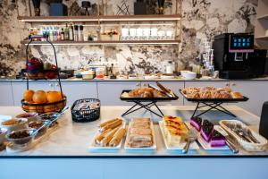 a bakery with various pastries and breads on a counter at Suncity Hotel & SPA in Šiauliai