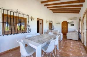 a dining room with a white table and white chairs at villa cap marti in El Tosalet