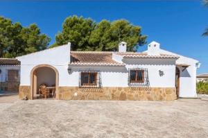 a large white house with a stone facade at villa cap marti in El Tosalet