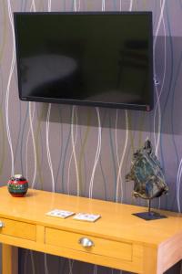 a flat screen tv on top of a wooden table at City Square Apartment in Chania