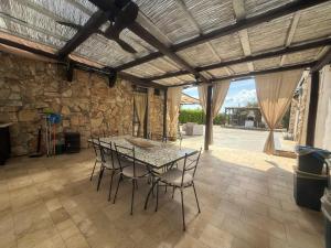 a table and chairs in a room with a stone wall at Amati home in Floridia