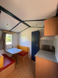 a room with a kitchen with a table and a counter at Camping Arquebuse in Auxonne