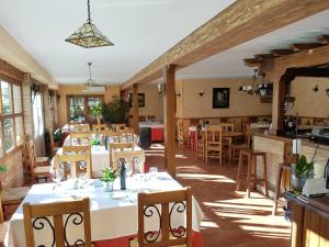 - un restaurant avec des tables et des chaises dans une salle dans l'établissement Casa Rural Puerto Del Emperador, à Aldeanueva de la Vera