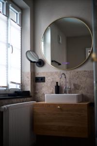 a bathroom with a sink and a mirror on the wall at Ferienwohnung "Haus Lehlgässchen" in Reil
