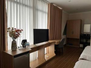 a hotel room with a desk with a television on it at Huỳnh Nga Măng Đen Hotel in Kon Plong +13 photos