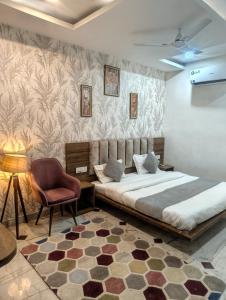 a bedroom with a bed and a chair at Hotel Jairaj in Alwar