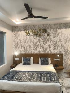 a bedroom with a bed and a ceiling fan at Hotel Jairaj in Alwar +12 photos