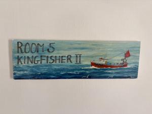 a painting of a boat in the ocean at Cadgwith Cove Inn in Cadgwith
