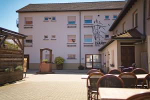 a hotel with tables and chairs in front of a building at La Clef des Champs - Proche Colmar in Biesheim
