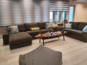 a living room with a couch and a table at THALIA, luxury 3Br Home with Ensuite Bathrooms, just 3 minutes walk from the beach located in the prestigious Athenian Riviera in Athens