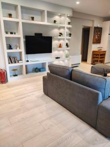 a living room with a couch and a flat screen tv at THALIA, luxury 3Br Home with Ensuite Bathrooms, just 3 minutes walk from the beach located in the prestigious Athenian Riviera in Athens