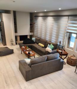 a living room with two couches and a table at THALIA, luxury 3Br Home with Ensuite Bathrooms, just 3 minutes walk from the beach located in the prestigious Athenian Riviera in Athens
