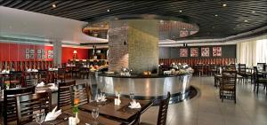 a restaurant with a bar and tables and chairs at Savoy Suites Manesar in Gurgaon
