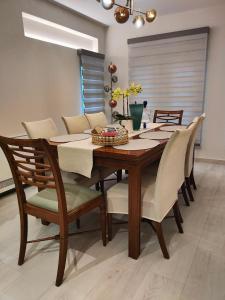 a dining room with a wooden table and chairs at THALIA, luxury 3Br Home with Ensuite Bathrooms, just 3 minutes walk from the beach located in the prestigious Athenian Riviera in Athens