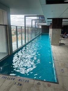 a swimming pool in a building with blue water at RNR on Franklin in Adelaide
