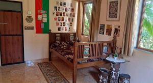 a room with a crib and a table and a window at Bageecha B&B- V A A Y U in Alībāg