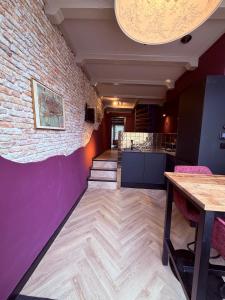 a room with purple walls and a brick wall at BNB de Victorie Alkmaar in Alkmaar