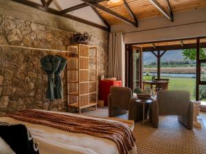a bedroom with a bed and a stone wall at Springfontein River Lodge in Stanford +47 photos