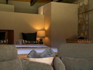 a bedroom with a bed and two chairs at Springfontein River Lodge in Stanford