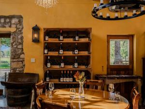 a room with a table with wine bottles on a shelf at Springfontein River Lodge in Stanford