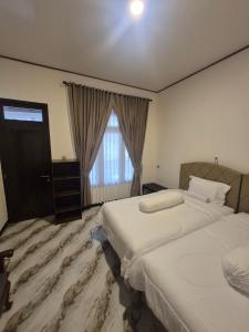 a hotel room with two beds and a window at d'Alvin Homestay 2 in Labuan Bajo +57 photos