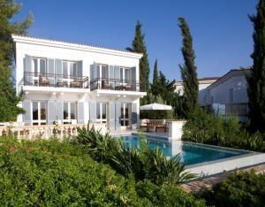 eine Villa mit Swimmingpool und einem Haus in der Unterkunft Anassa in Polis Chrysochous