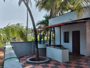 a building with a palm tree in front of it at Samudra Nadi Bliss in Mūlki