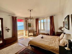 a bedroom with a bed and a large window at Villa Tricia Cannes in Cannes