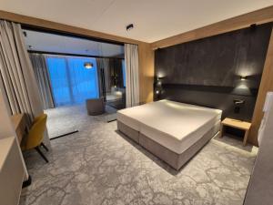 a bedroom with a large bed and a bathroom at MEANDER THERMAL & SKI REZORT ORAVICE in Oravice