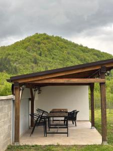 a pavilion with a table and chairs on a patio at Vikendica Casa Verde in Konjic