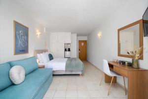 a living room with a bed and a blue couch at Flisvos in Sitia