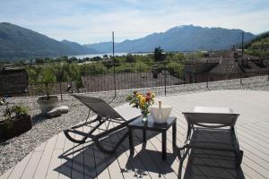 a patio with two chairs and a table with flowers at La Porta Segreta del Rustico in Gordola