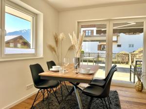 a dining room with a wooden table and chairs at Ferienhaus Alpenlodge in Oberstdorf