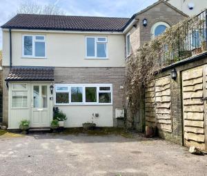a white house with a gate and a driveway at Anjou Bijou in Westbury-sub-Mendip