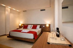 a bedroom with a bed and a table with wine glasses at Zia Nì Boutique Suites in Peschici