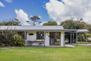 a small white house with a picnic table in a yard at Surfside Ocean Beach Denmark Holiday Accommodation in Denmark