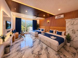 a hotel room with two beds and a couch and a television at Trishul inn in Rudraprayāg
