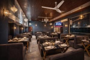 a restaurant with tables and chairs and a ceiling fan at Trishul inn in Rudraprayāg